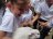 Estudiantes sonríen y muestran emoción con un conejo blanco.
