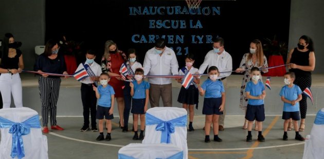 Personas de diferentes edades cortan cinta de bandera