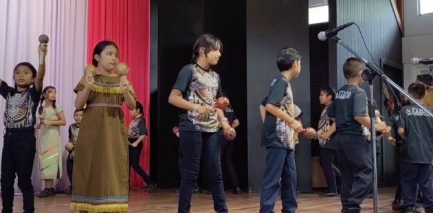 Estudiantes tocando instrumentos musicales y cantando
