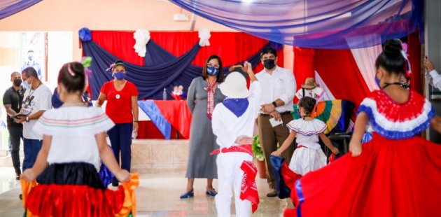 Ministra observa a niñas y niños engalanados en vestidos de colores patrios
