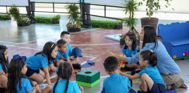 Estudiantes aprendiendo inglés con su maestra