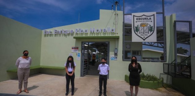 Ministra y comunidad educativa posan frente a la nueva escuela 