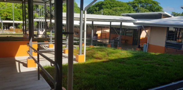 Se aprecia una escuela iluminada por el sol del atardecer.