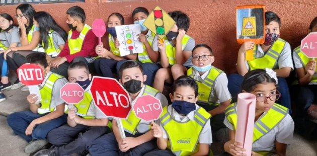 Estudiantes de primaria con chalecos preventivos para andar por la vía pública