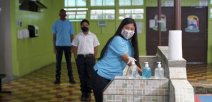 Imagen muestra a estudiantes con lavado de manos y distanciamiento