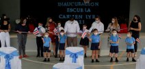 Personas de diferentes edades cortan cinta de bandera