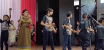 Estudiantes tocando instrumentos musicales y cantando