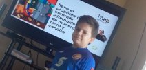Foto muestra a estudiante estudiando con la televisión 
