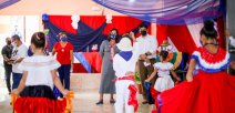 Ministra observa a niñas y niños engalanados en vestidos de colores patrios