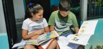 Dos niños con libros y dibujando. 