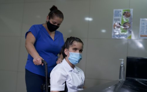 Estudiante en silla de ruedas cerca de lavado de manos