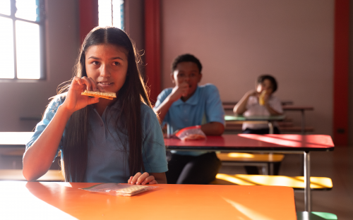 Estudiantes merendando, respetando el distanciamiento físico recomendado