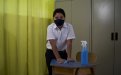 Estudiante limpiando un pupitre dentro de un aula