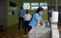Tres estudiantes con mascarilla en el centro educativo haciendo fila 