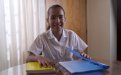 Estudiante de escuela en su casa, abriendo cuadernos en la mesa del comedor