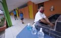 Tres estudiantes con mascarilla en el centro educativo haciendo fila