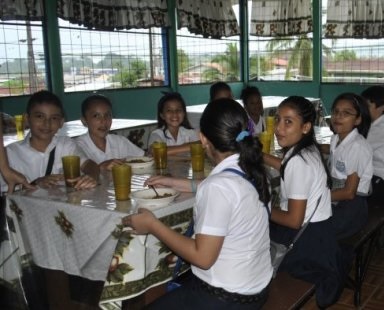 Estudiantes sentados alrededor de una mesa en comedor estudiantil